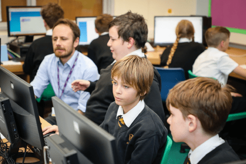 Education Recruitment Supply Teacher Teaching Pupils in an IT suite