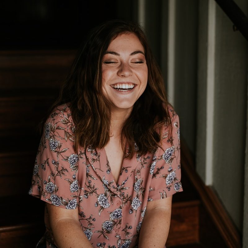 woman sitting on wooden stair smiling