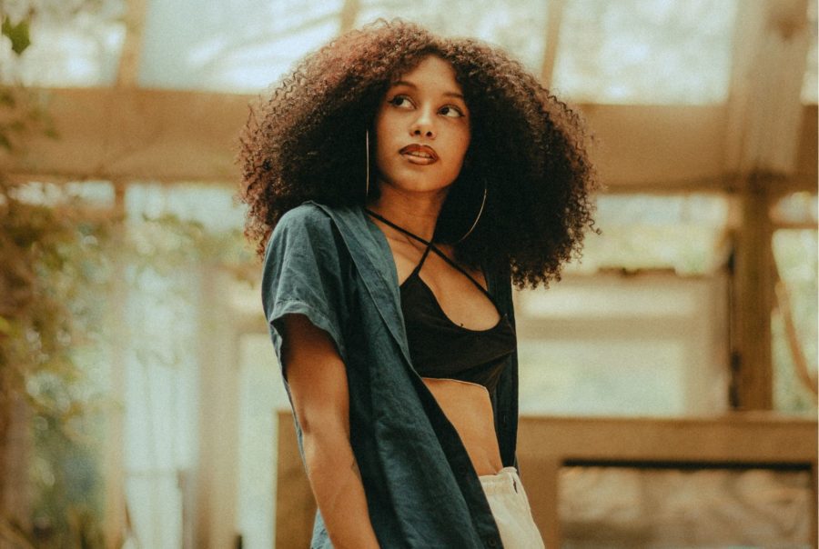 Young woman in greenhouse dressed in sustainable fashion