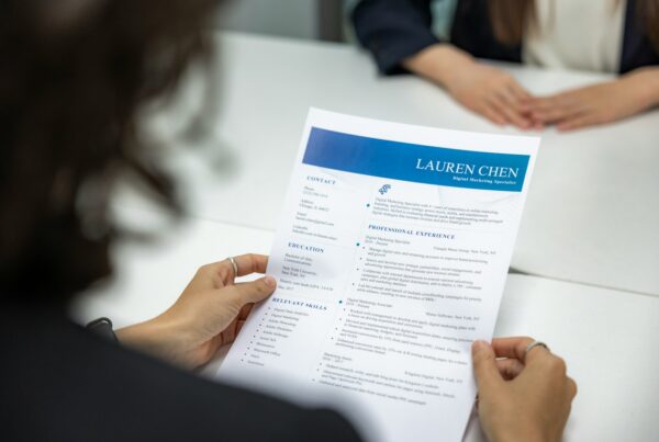 a woman is reading a resume at a table