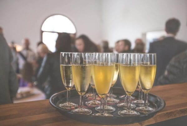 A sophisticated event with champagne glasses at a lively social gathering indoors.