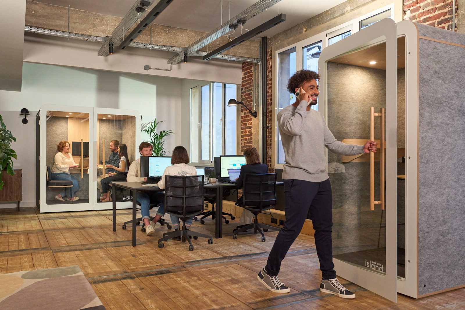 A man walking in a room with a phone to his ear