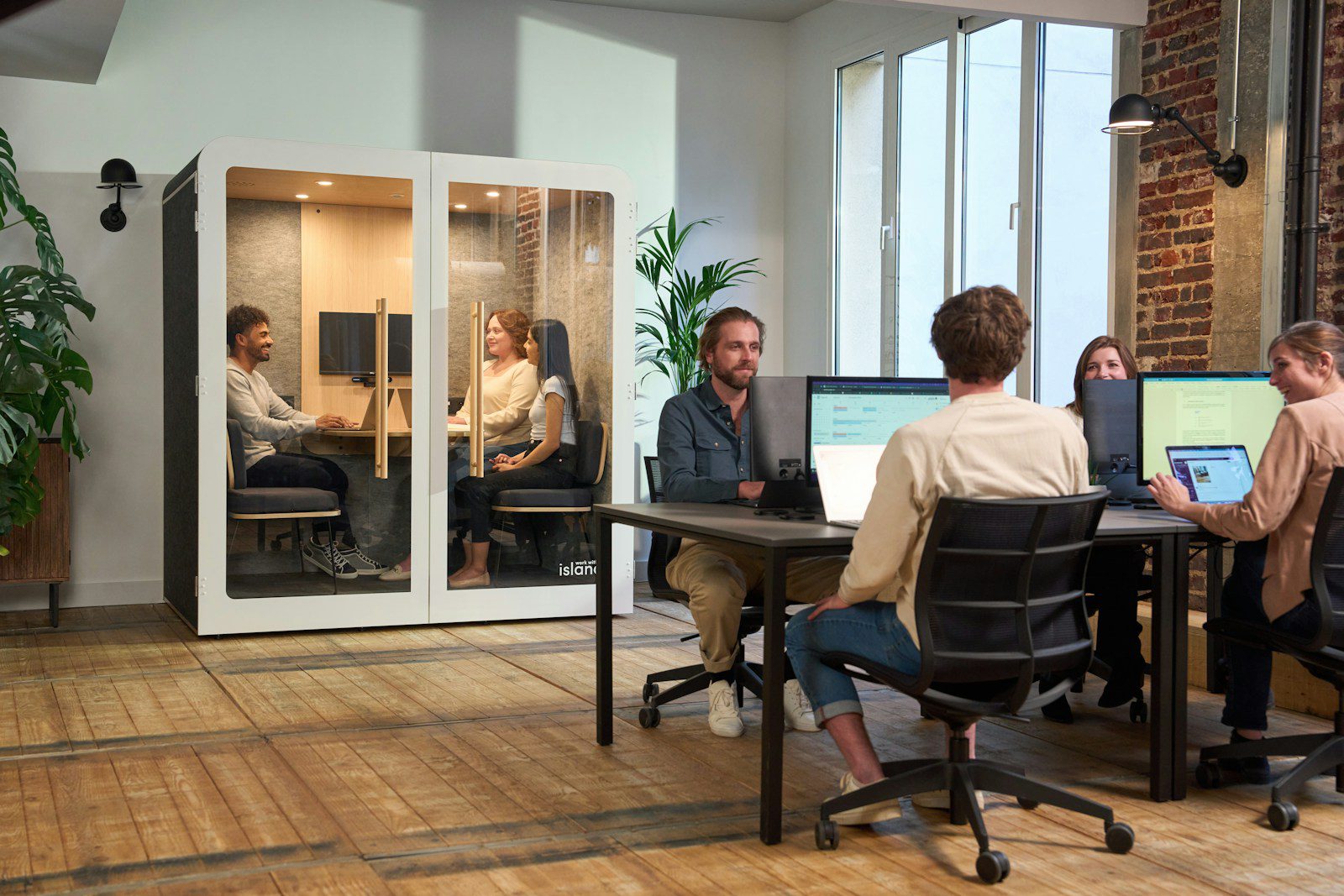 A group of people sitting around a table working on computers