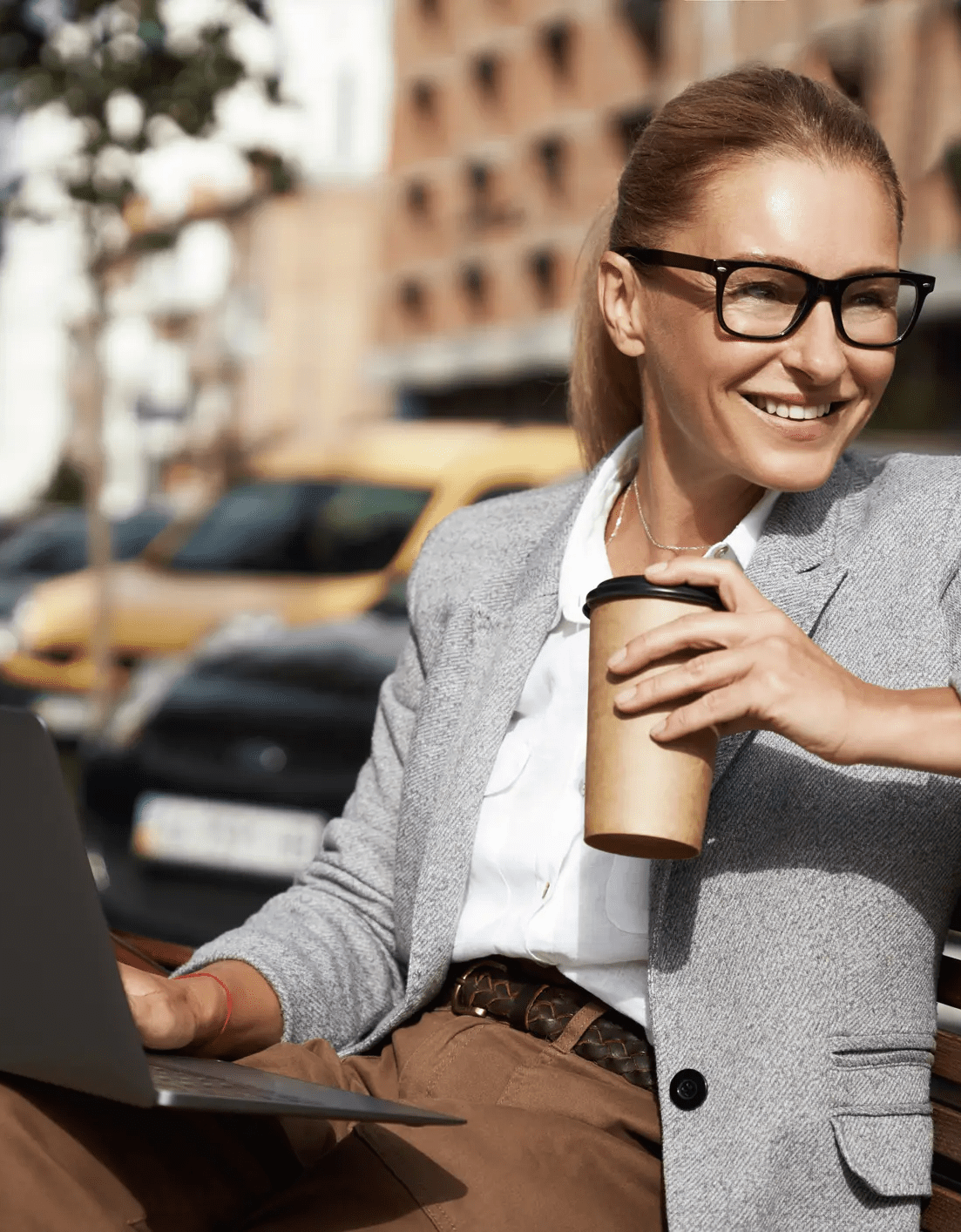 woman holding a pc and a coffee